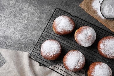 Photo of Delicious sweet buns, powdered sugar and strainer on gray table, flat lay. Space for text
