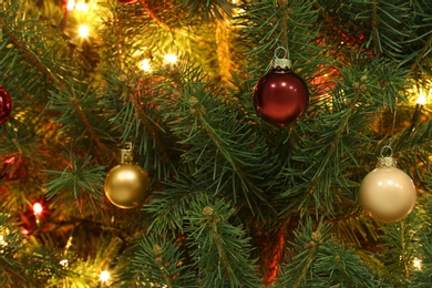 Glowing bright fairy lights and beautiful baubles on Christmas tree