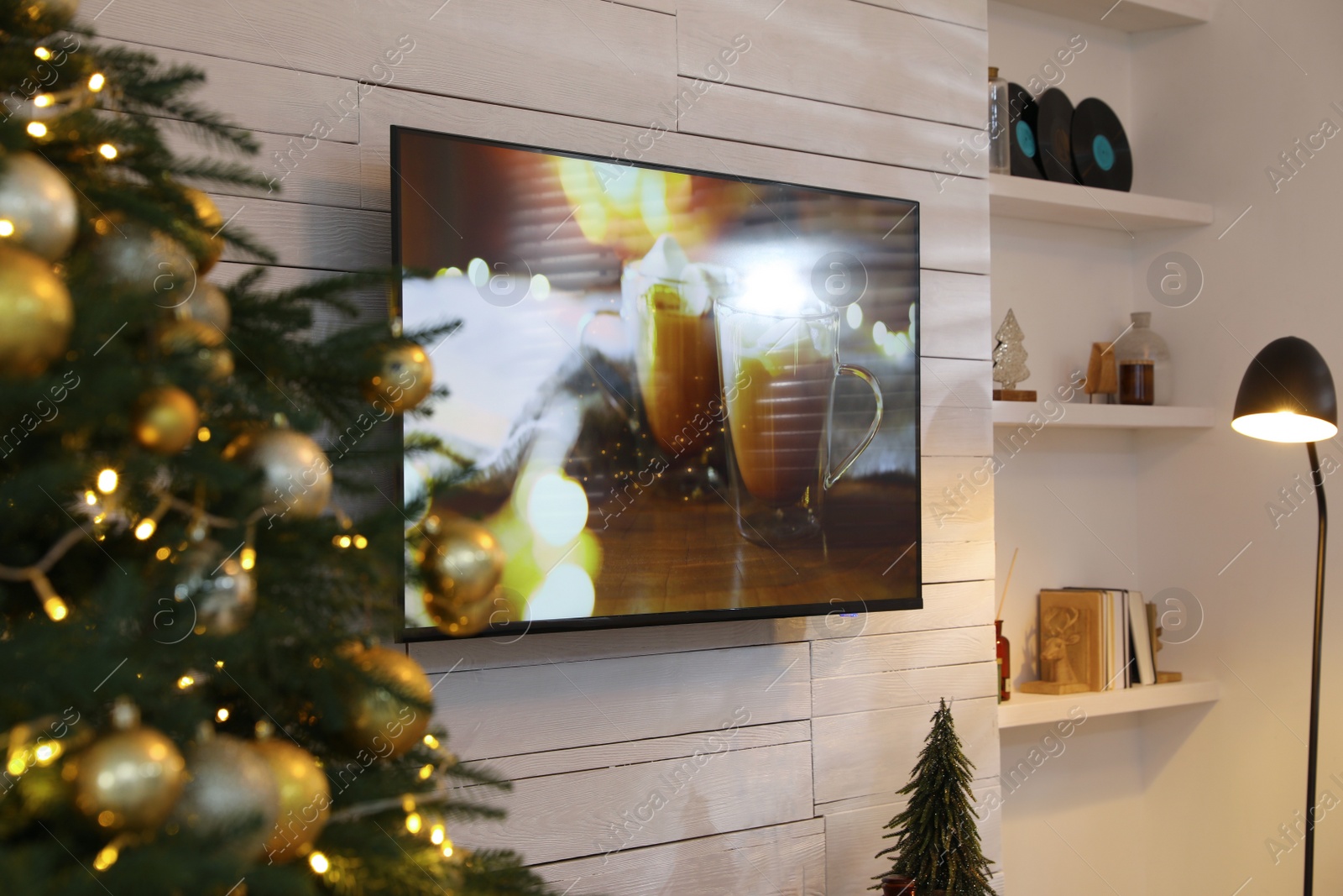 Photo of Plasma TV on white wooden wall in living room beautifully decorated for Christmas