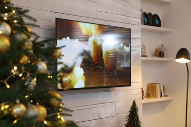 Plasma TV on white wooden wall in living room beautifully decorated for Christmas