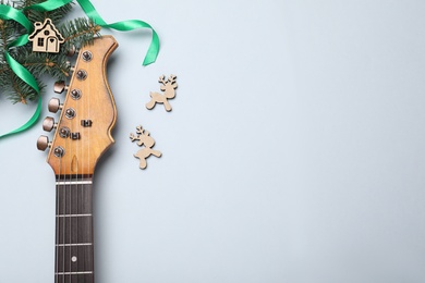 Christmas music. Flat lay composition with guitar on white background, space for text
