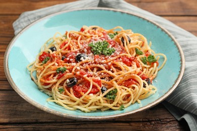 Photo of Delicious pasta with tomatoes, olives and parmesan cheese on wooden table, closeup