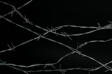 Photo of Shiny metal barbed wire on black background