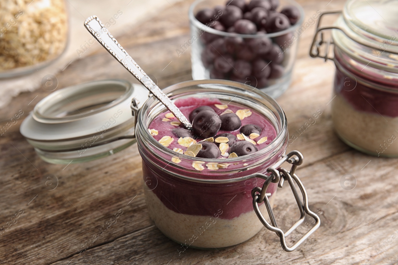 Photo of Jar with tasty acai smoothie on wooden table