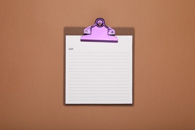 Photo of Clipboard with to do notes for daily planning on brown background, top view. Space for text