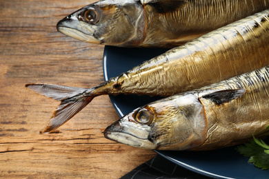 Photo of Tasty smoked fish on wooden table, closeup