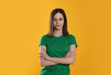 Photo of Portrait of cute teenage girl on orange background