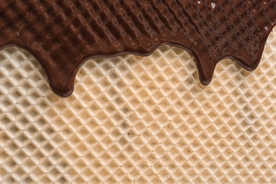 Hot dark chocolate on wafer, closeup. Crispy food