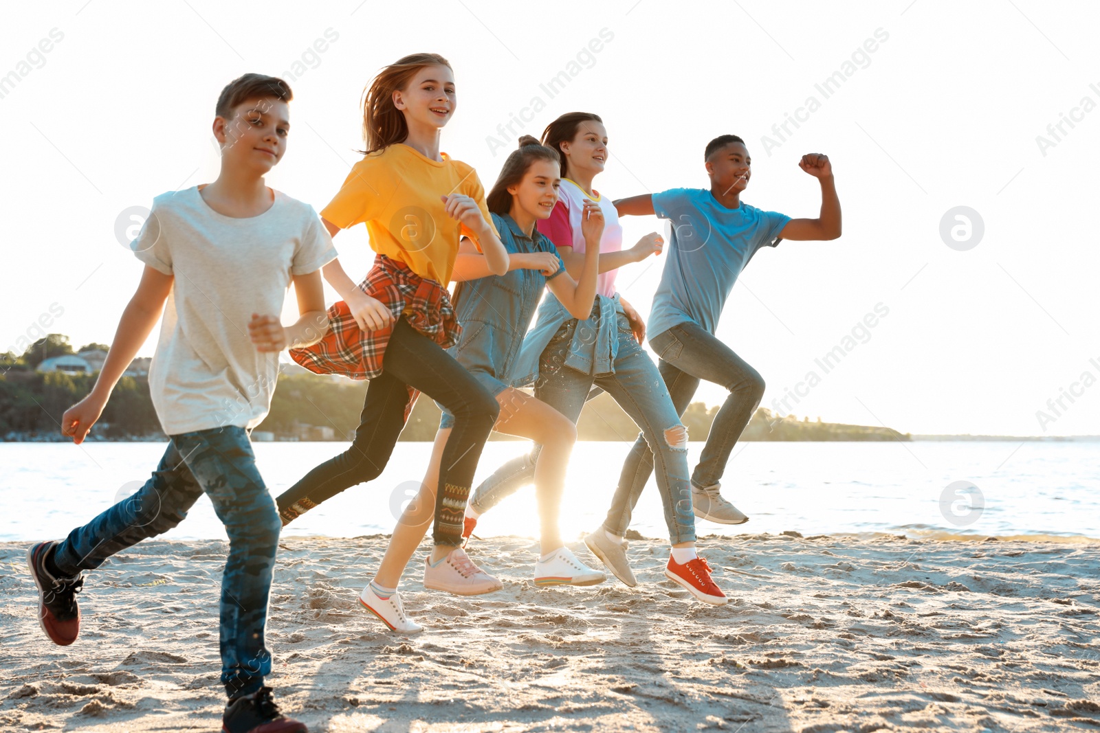 Photo of Group of children running on beach. Summer camp