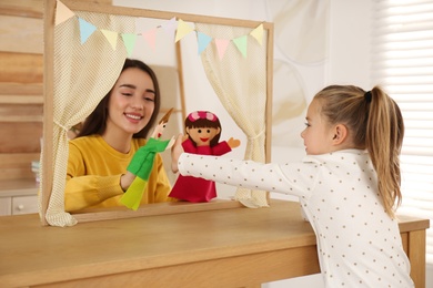 Mother performing puppet show for her daughter at home