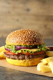 Photo of Burger with delicious patty and french fries on table