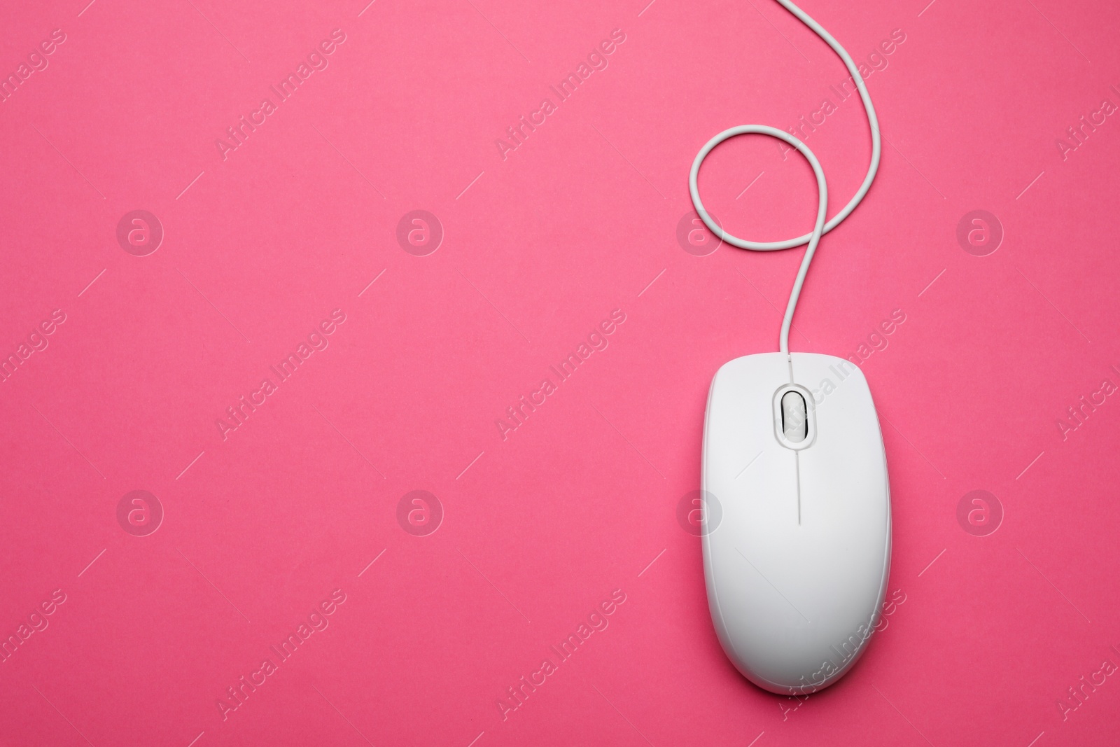 Photo of Wired computer mouse on pink background, top view. Space for text