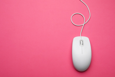 Photo of Wired computer mouse on pink background, top view. Space for text