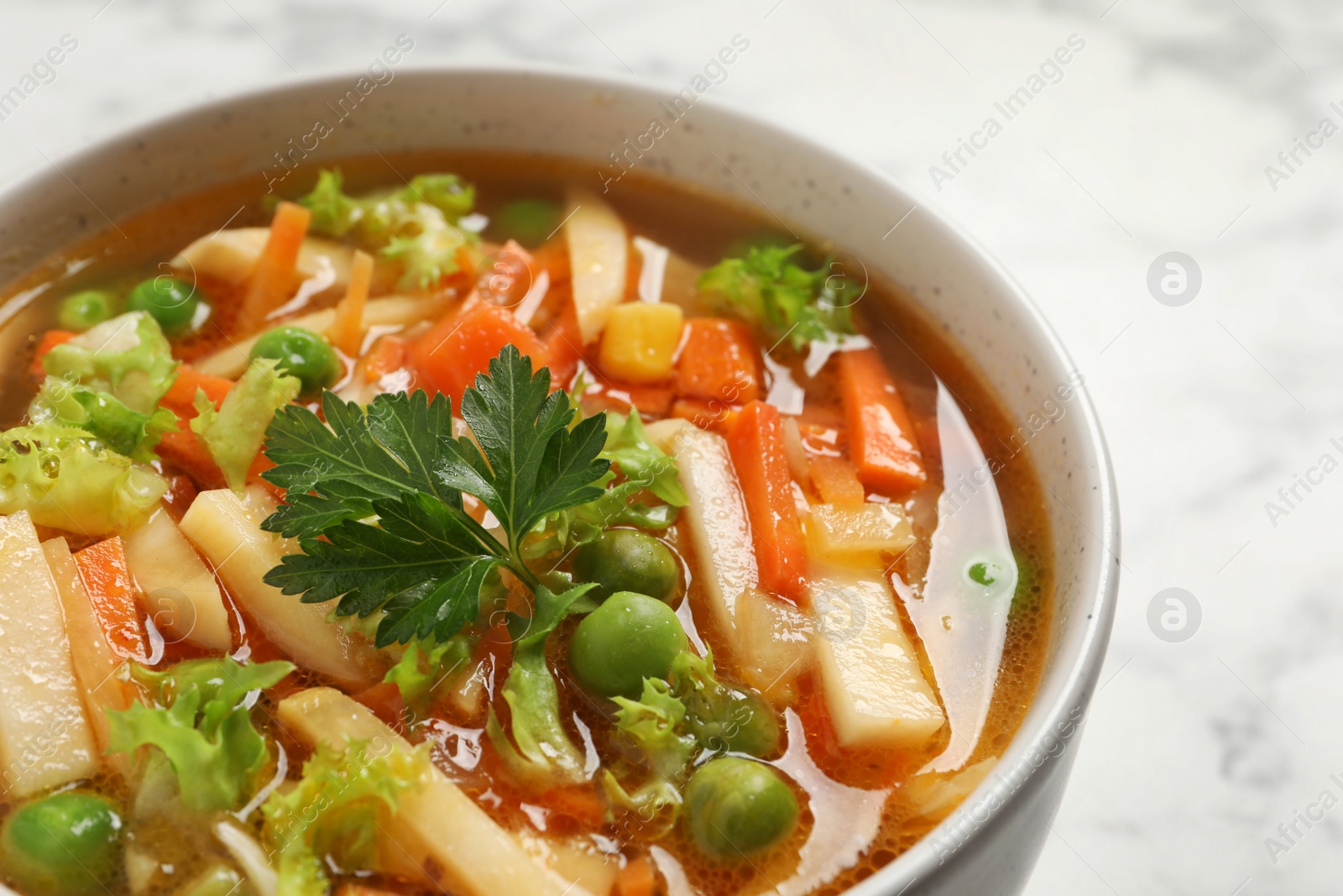 Photo of Bowl of delicious turnip soup on white table, closeup