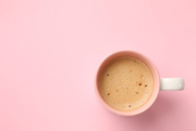 Photo of Aromatic coffee in cup on pink background, top view. Space for text