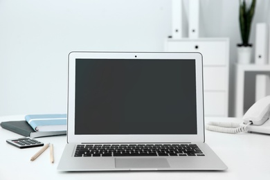 Photo of Stylish workplace with modern laptop on desk