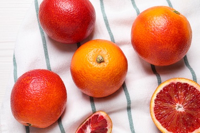 Fresh ripe red oranges on white wooden table, flat lay