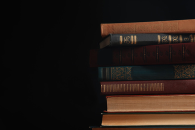 Photo of Collection of different books on dark background. Space for text