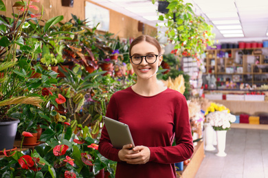 Photo of Female business owner with tablet in flower shop
