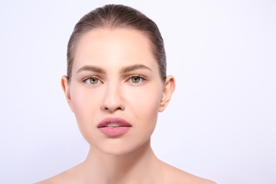 Photo of Beautiful woman with perfect eyebrows on light background