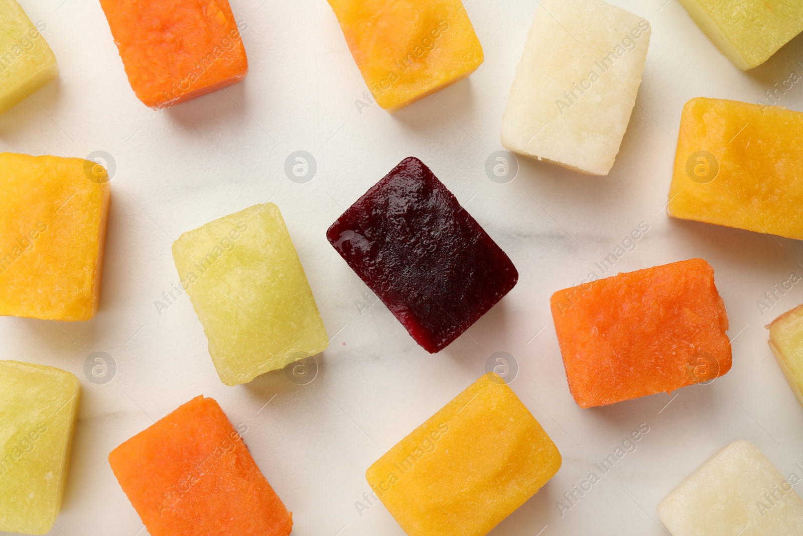 Photo of Frozen vegetable puree cubes on white table, flat lay