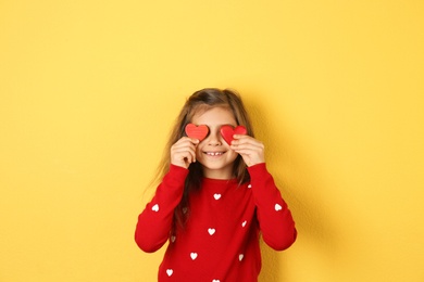 Portrait of girl with decorative hearts on color background