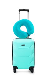 Photo of Soft travel pillow on turquoise suitcase isolated on white