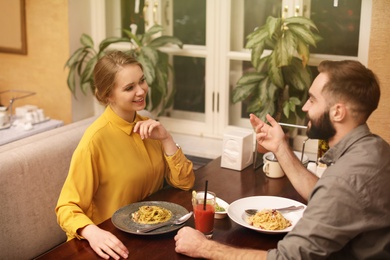 Photo of Lovely young couple having pasta carbonara for dinner at restaurant