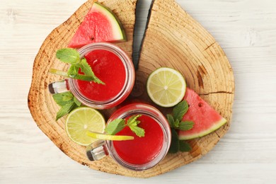 Photo of Tasty summer watermelon drink, limes and mint on white wooden table, top view