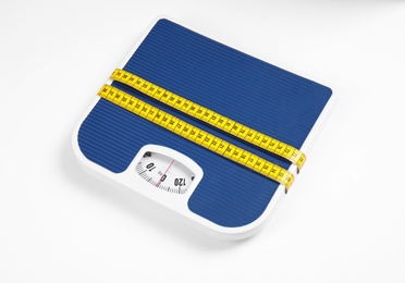 Photo of Modern scales and tape measure isolated on white