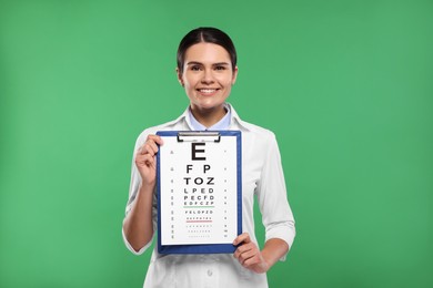 Photo of Ophthalmologist with vision test chart on green background