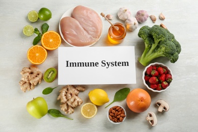 Card with phrase Immune System and fresh products on light table, flat lay