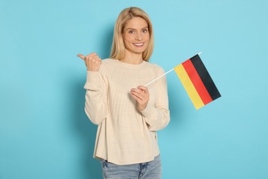 Woman with flag of Germany on light blue background