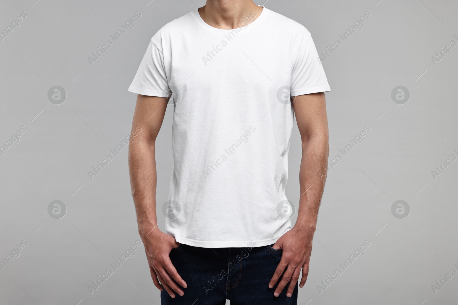 Photo of Man in white t-shirt on grey background, closeup