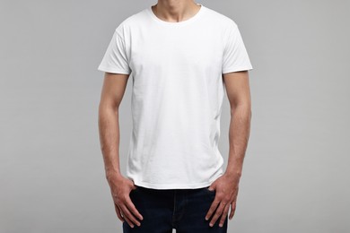 Man in white t-shirt on grey background, closeup