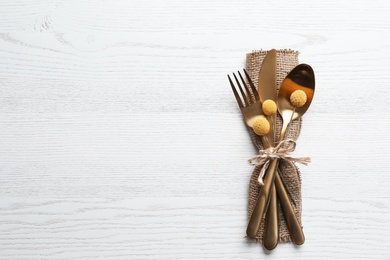 Photo of Top view of cutlery decorated for autumn table setting on white wooden background, space for text