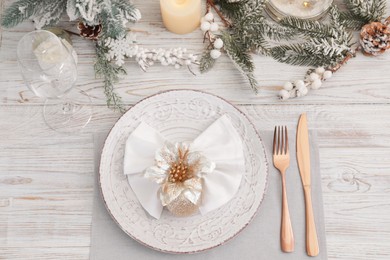 Photo of Festive place setting with beautiful dishware, cutlery and decor for Christmas dinner on white wooden table, flat lay