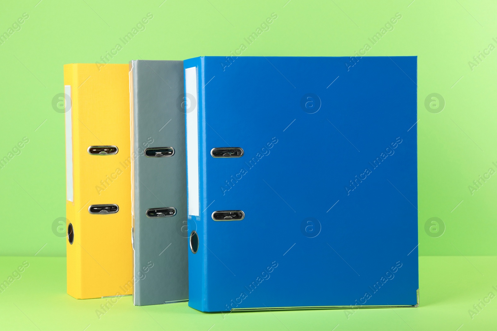 Photo of Bright hardcover office folders on light green background