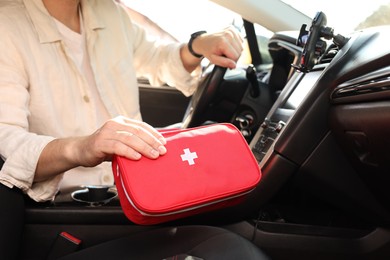 Photo of Man with first aid kit inside car, closeup