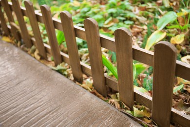 Photo of Closeup view of small wooden fence outdoors