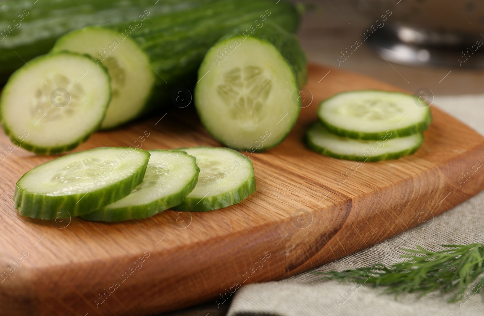 Photo of Cucumbers, cutting board and dill on table, closeup