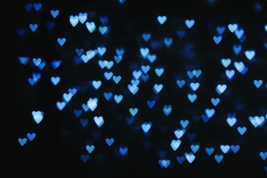 Photo of Blurred view of beautiful heart shaped lights on dark background