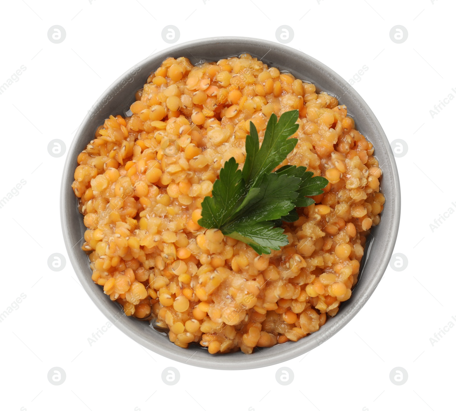Photo of Delicious red lentils with parsley in bowl isolated on white, top view