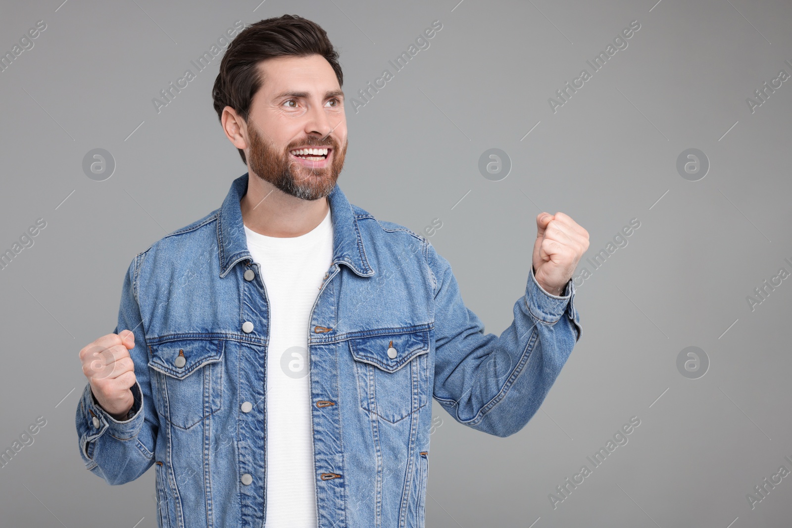 Photo of Portrait of happy surprised man on grey background, space for text