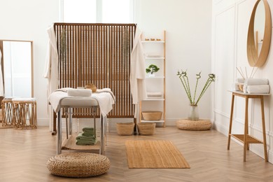 Photo of Stylish room interior with massage table in spa salon