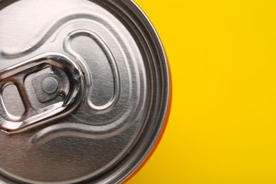 Energy drink in can on yellow background, top view. Space for text