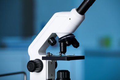 Photo of Modern medical microscope with glass slide on blurred background, closeup