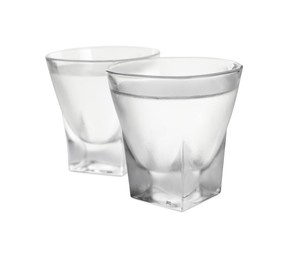 Vodka in shot glasses on white background