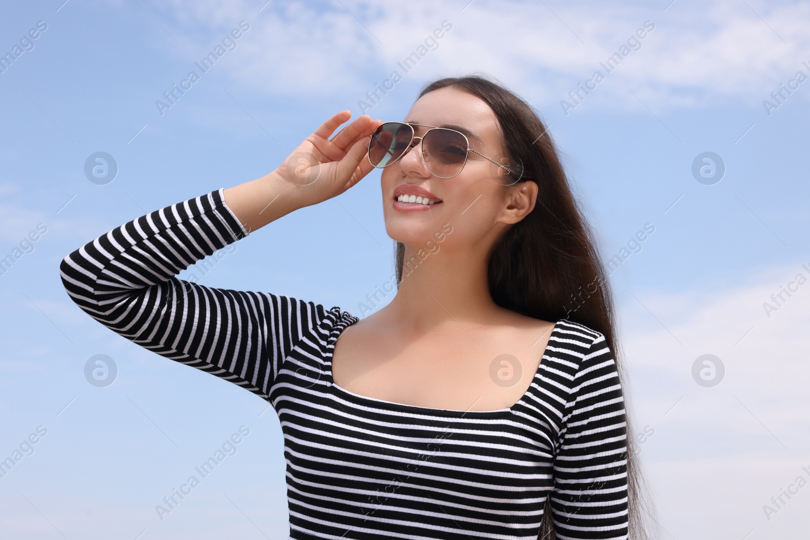 Photo of Beautiful smiling woman wearing stylish sunglasses outdoors