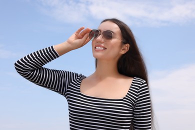 Photo of Beautiful smiling woman wearing stylish sunglasses outdoors